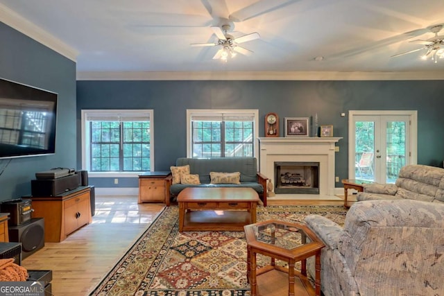 living room with french doors, light wood-type flooring, ceiling fan, and ornamental molding