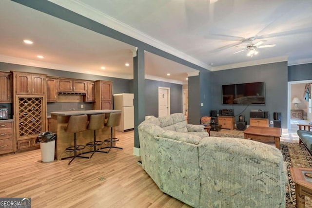 living room featuring ceiling fan, light hardwood / wood-style floors, and ornamental molding