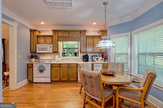 kitchen featuring plenty of natural light, white appliances, hanging light fixtures, and light hardwood / wood-style flooring