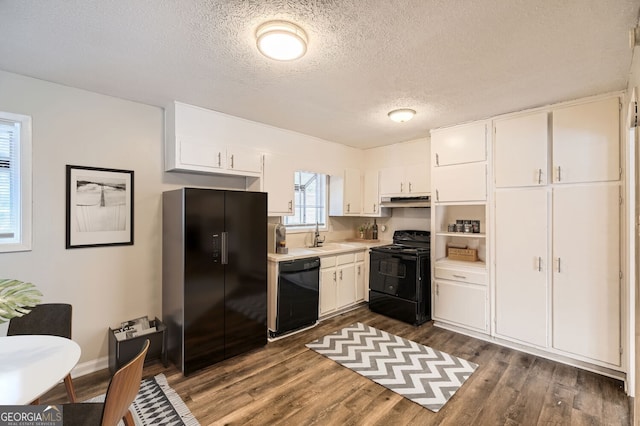 kitchen featuring a textured ceiling, sink, black appliances, white cabinets, and dark hardwood / wood-style floors