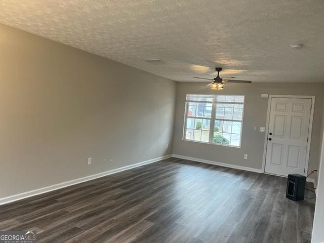 unfurnished living room with a textured ceiling, ceiling fan, and dark hardwood / wood-style flooring