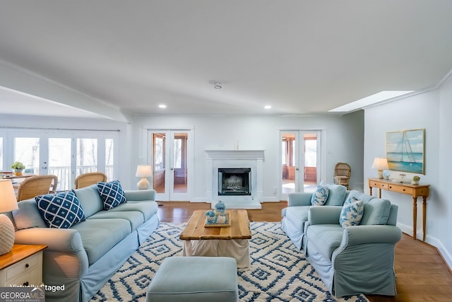 living room with light wood-type flooring, ornamental molding, and french doors