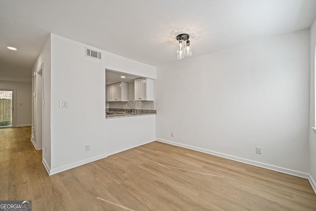 unfurnished living room featuring light hardwood / wood-style floors and sink