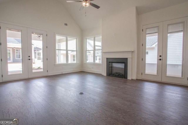 unfurnished living room featuring ceiling fan, dark wood-type flooring, high vaulted ceiling, and french doors