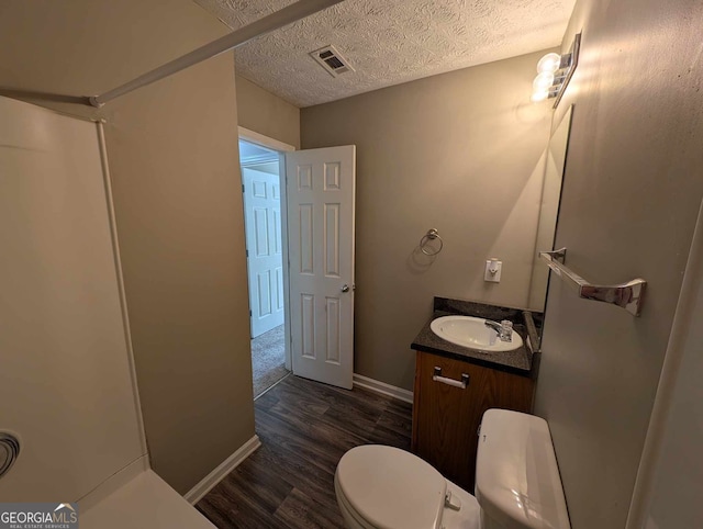 bathroom featuring hardwood / wood-style floors, vanity, a textured ceiling, and toilet