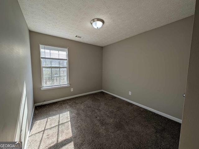 carpeted empty room with a textured ceiling