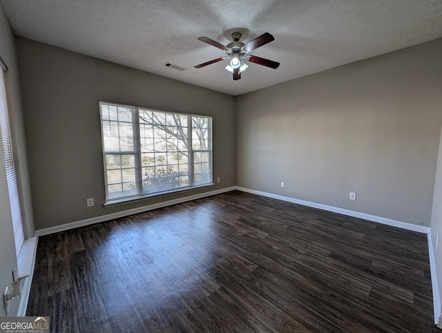 spare room featuring a textured ceiling, ceiling fan, and dark wood-type flooring