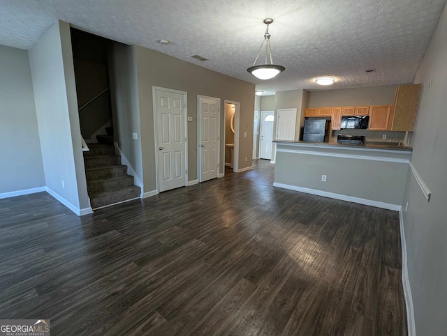 unfurnished living room with a textured ceiling and dark hardwood / wood-style flooring