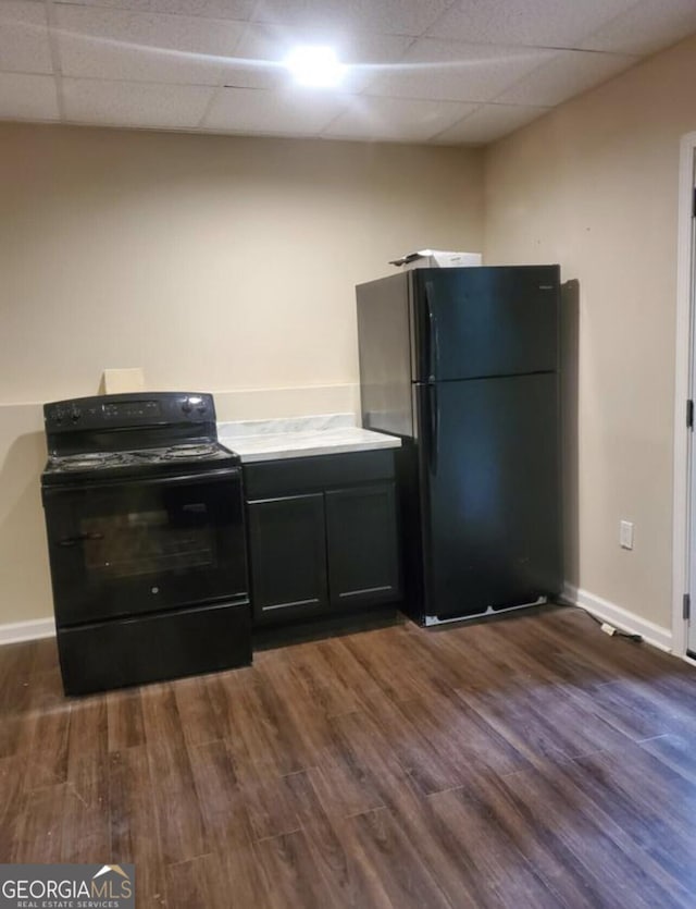 kitchen with a paneled ceiling, dark hardwood / wood-style floors, and black appliances