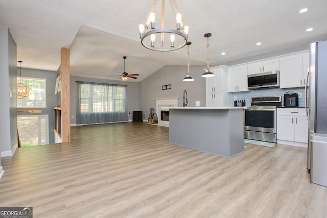 kitchen with decorative backsplash, a kitchen island, stainless steel appliances, and decorative light fixtures