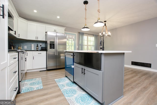 kitchen featuring backsplash, an island with sink, pendant lighting, white cabinets, and appliances with stainless steel finishes