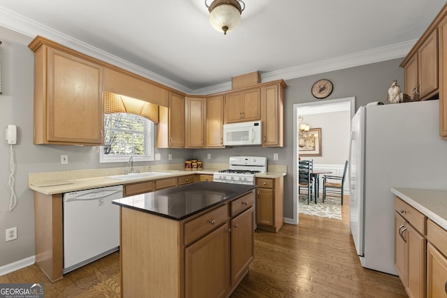 kitchen with crown molding, white appliances, hardwood / wood-style flooring, and a kitchen island