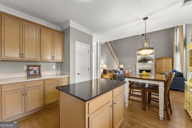 kitchen featuring crown molding, hanging light fixtures, light hardwood / wood-style flooring, light brown cabinets, and a kitchen island