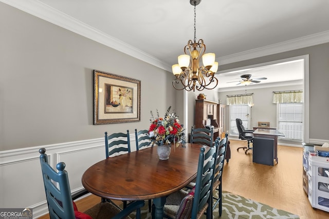 dining room featuring hardwood / wood-style flooring, ornamental molding, and ceiling fan with notable chandelier