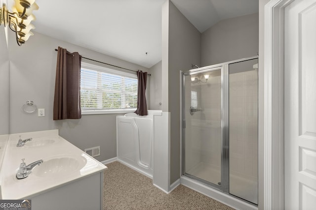 bathroom with walk in shower, tile patterned floors, vanity, and vaulted ceiling