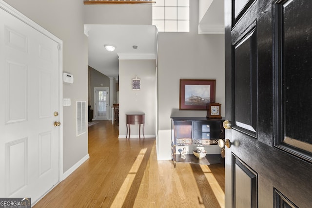 entryway featuring crown molding and hardwood / wood-style floors