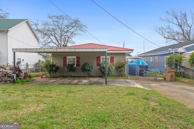 rear view of property featuring a lawn and a carport