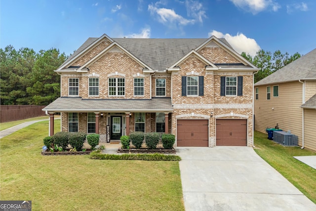 view of front facade with a porch, central AC, a garage, and a front lawn