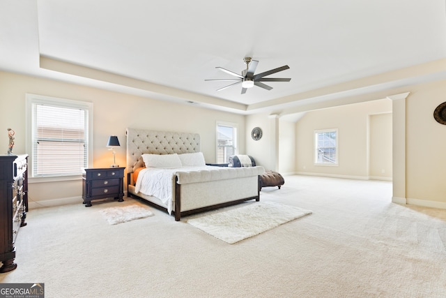 bedroom with a tray ceiling, ceiling fan, and light colored carpet