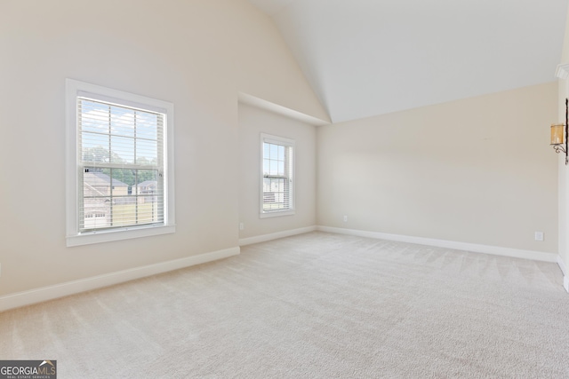 carpeted spare room featuring high vaulted ceiling