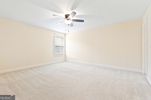 spare room with ceiling fan and light colored carpet