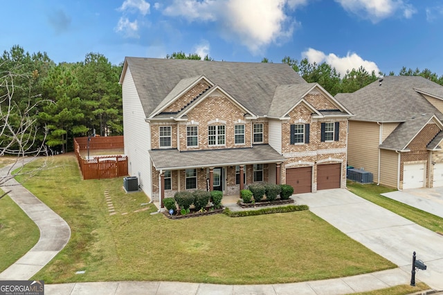 view of front of house with covered porch, central AC, a garage, and a front yard