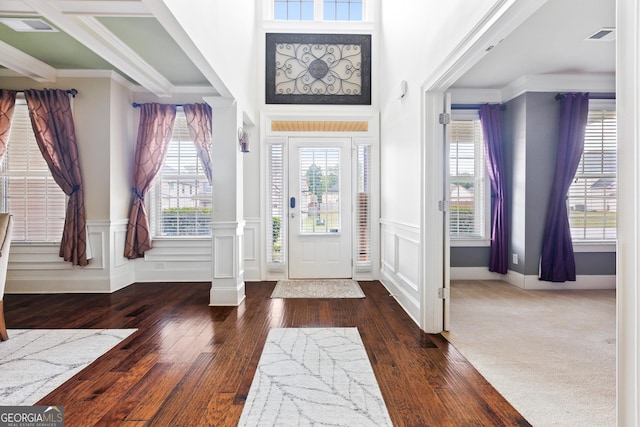 entryway with crown molding, plenty of natural light, and dark wood-type flooring