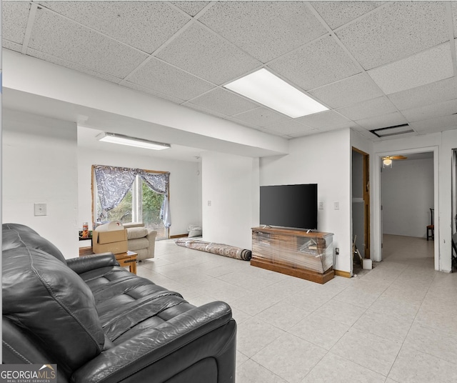 living room with ceiling fan and a drop ceiling