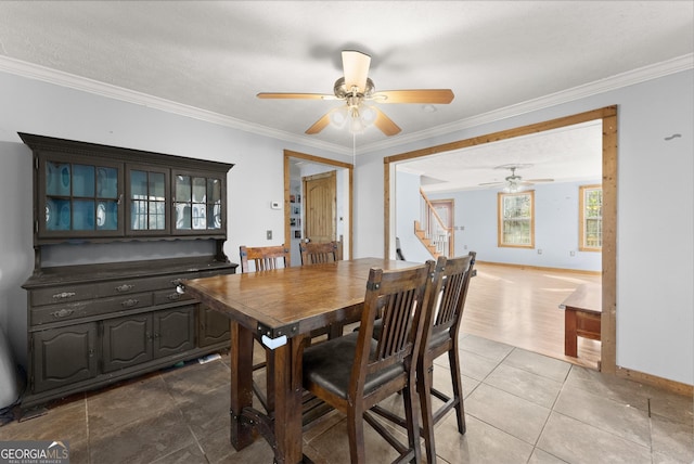 tiled dining area with ceiling fan, a textured ceiling, and ornamental molding