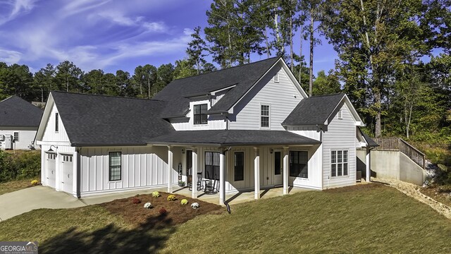 modern farmhouse style home with a front lawn, a porch, and a garage