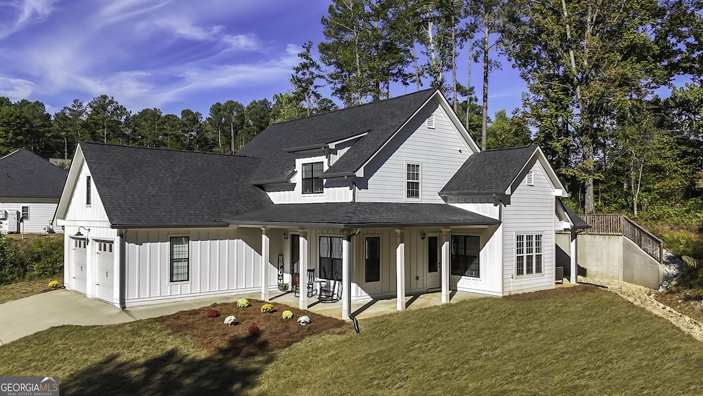 view of front of property featuring a garage, a patio area, and a front yard