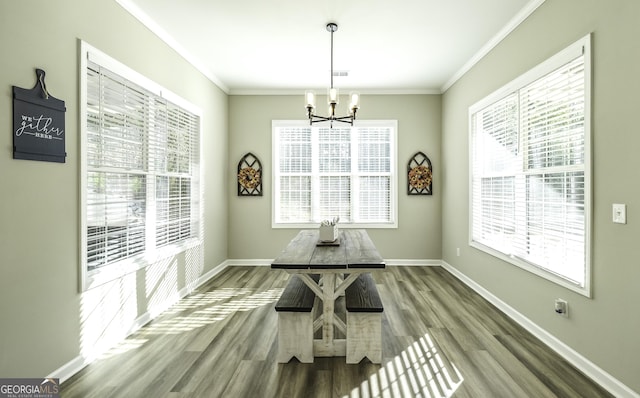 dining room with hardwood / wood-style flooring, crown molding, and a chandelier