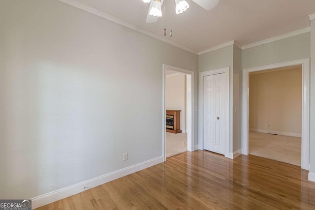 empty room featuring hardwood / wood-style flooring, ceiling fan, and crown molding