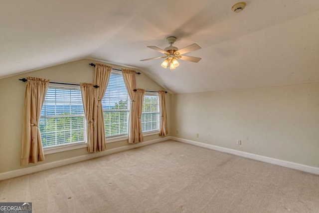 additional living space featuring light carpet, plenty of natural light, ceiling fan, and lofted ceiling