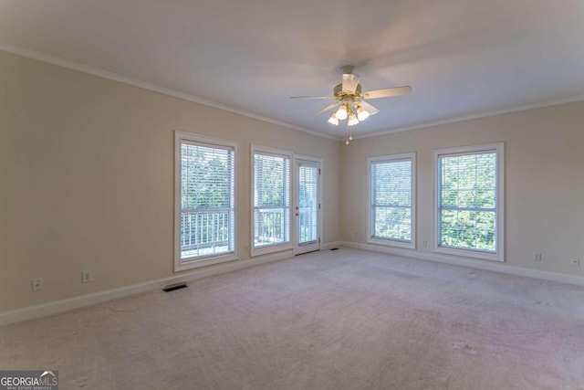 carpeted spare room with ceiling fan and ornamental molding