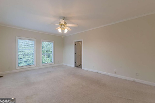 carpeted spare room featuring crown molding and ceiling fan