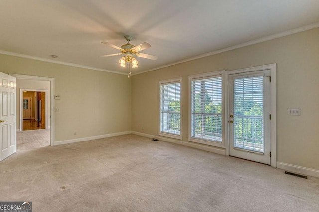 carpeted spare room with ceiling fan and ornamental molding