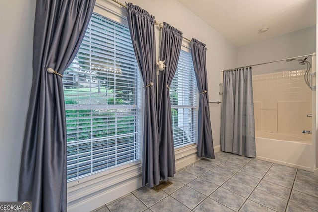 bathroom featuring a healthy amount of sunlight, tile patterned floors, and shower / bath combo with shower curtain