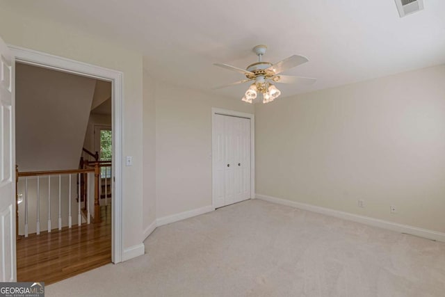 carpeted spare room with ceiling fan