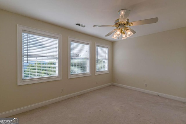 empty room with ceiling fan and light colored carpet