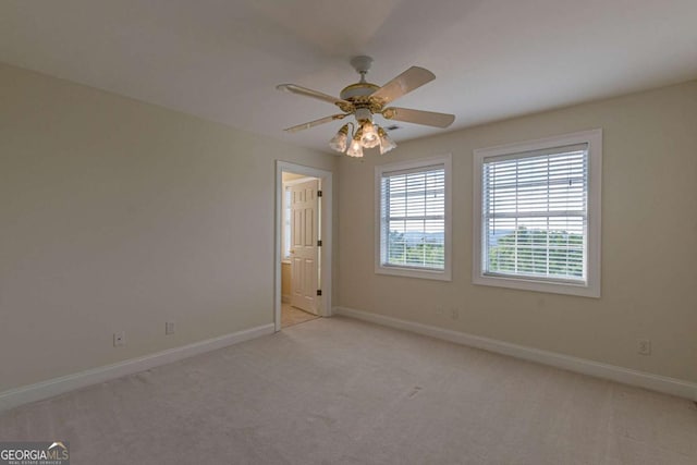 spare room featuring light colored carpet and ceiling fan