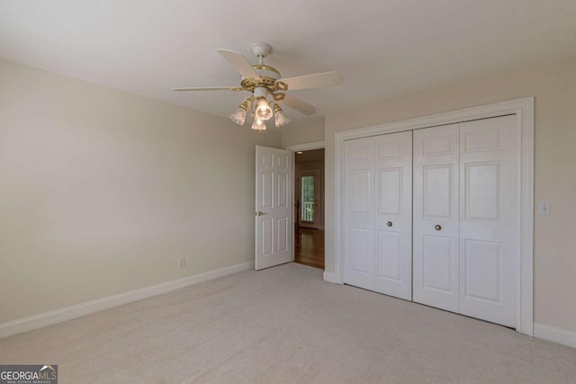 unfurnished bedroom with ceiling fan, light colored carpet, and a closet