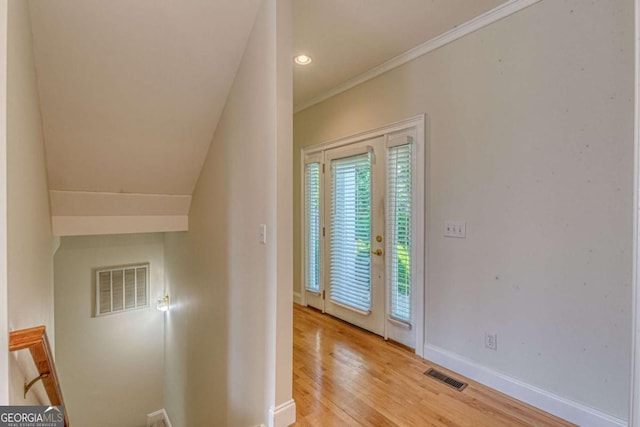 entryway with crown molding and light hardwood / wood-style floors