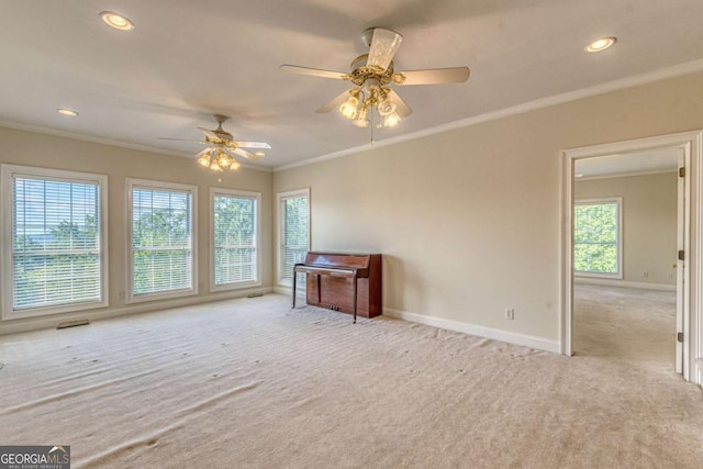 empty room with ceiling fan, light colored carpet, and crown molding