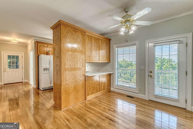 kitchen featuring ceiling fan, light wood-type flooring, white fridge with ice dispenser, and ornamental molding