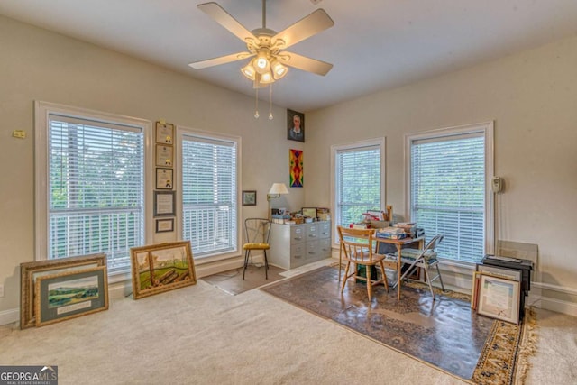 dining area with ceiling fan and light carpet