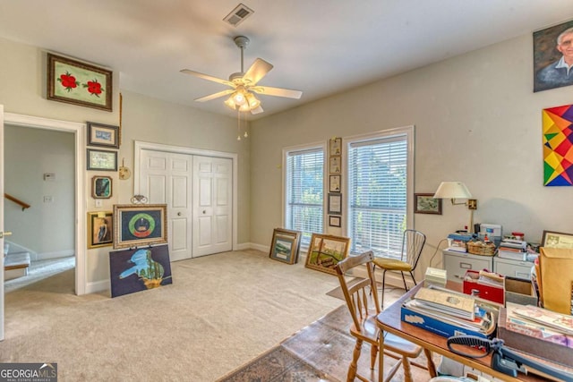 carpeted office space featuring ceiling fan