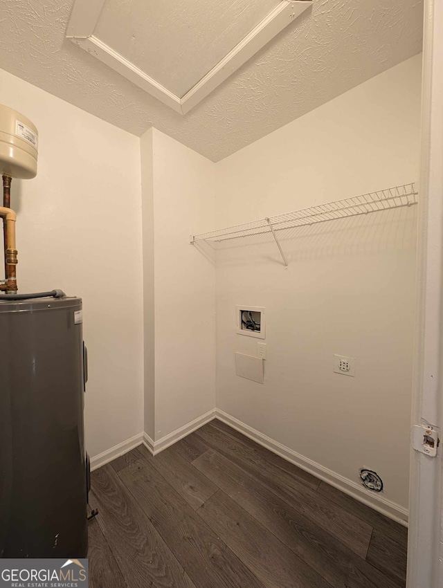 laundry room featuring washer hookup, dark hardwood / wood-style floors, a textured ceiling, and water heater