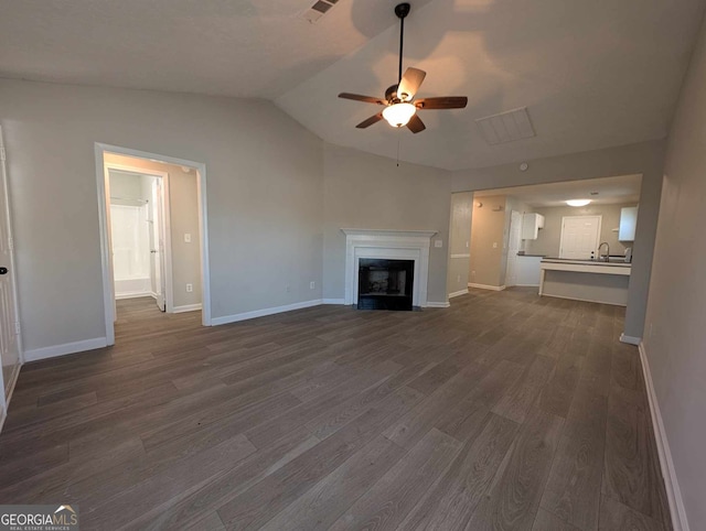 unfurnished living room featuring ceiling fan, dark hardwood / wood-style flooring, and vaulted ceiling