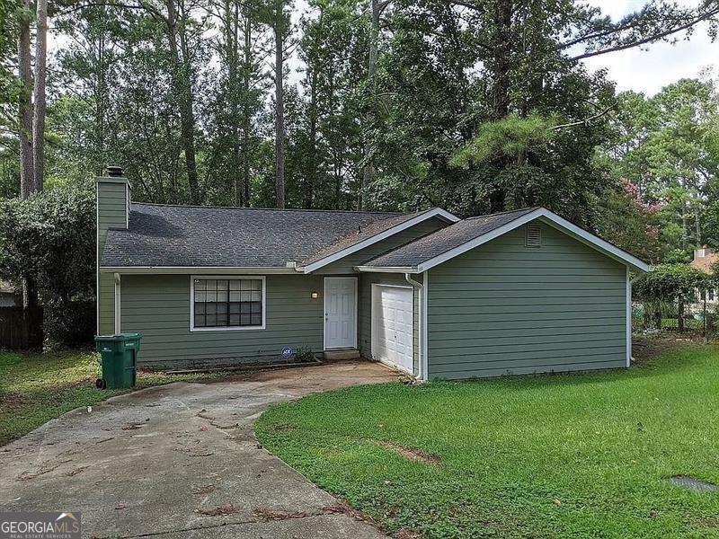 single story home featuring a garage and a front lawn